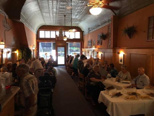 A bustling restaurant interior with diners at tables, enjoying meals and conversation in a warm, inviting atmosphere.