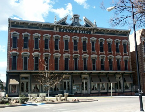 Historic Plaza Hotel building with a red brick facade and decorative architectural details under a blue sky.