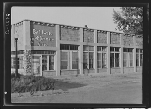 Historic building of Baldwin Co-op Creamery Association, featuring large windows and a stone facade.