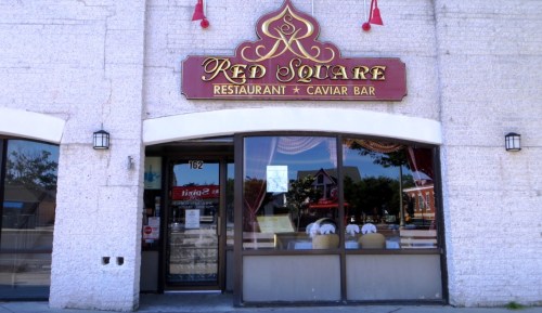 Exterior of Red Square Restaurant and Caviar Bar, featuring a decorative sign and large front windows.
