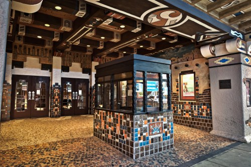 Colorful entrance with intricate tile work and wooden beams, featuring a ticket booth and decorative walls.