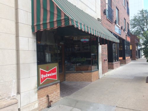 A storefront with a green and white striped awning, featuring a Budweiser sign and the name "Bocie's" visible.