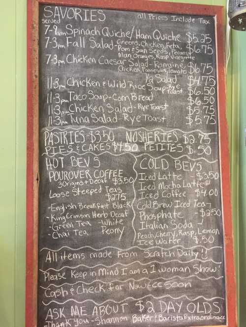 Menu board featuring savory dishes, pastries, cold beverages, and daily specials with prices listed.