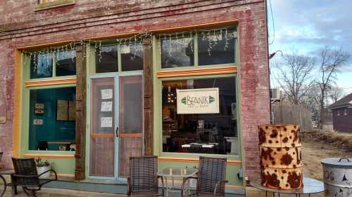 A colorful café exterior with large windows, a sign reading "Bean," and rustic seating outside.