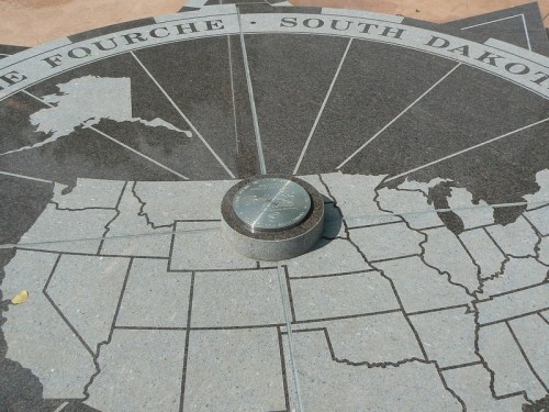 A granite map of South Dakota with a central marker, showing state outlines and directional lines.