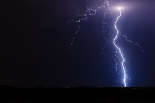 A dramatic night sky illuminated by multiple lightning strikes against a dark backdrop.