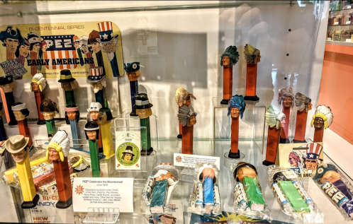 Display of vintage PEZ dispensers featuring various characters, including historical figures and themed designs.