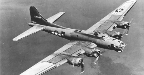 A vintage B-17 bomber flying over the ocean, showcasing its distinctive wings and propellers.