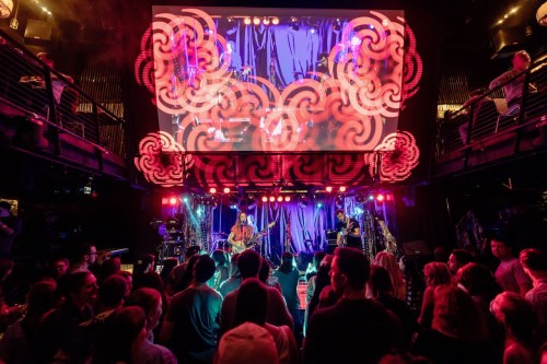 A lively concert scene with a band performing on stage, colorful lights, and an audience enjoying the show.