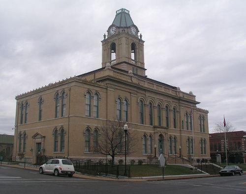 Historic building with a clock tower, featuring ornate architecture and a cloudy sky in the background.