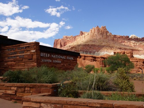 Visitor center at Capitol Reef National Park, with red rock formations and blue sky in the background.