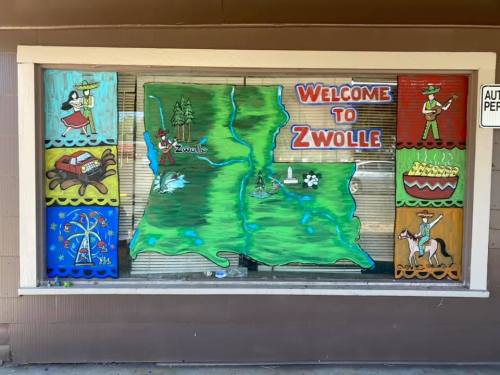 Colorful mural depicting the state of Louisiana with "Welcome to Zwolle" and various local scenes and characters.