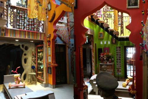 Colorful interior of a vibrant, artistic space featuring decorative elements, stairs, and unique artwork.