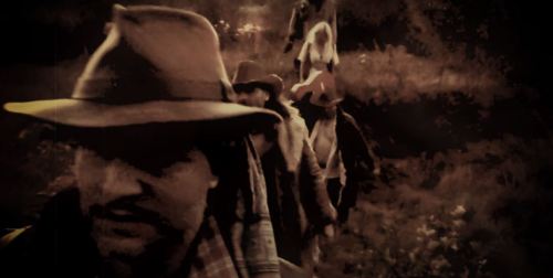 A group of people wearing hats and coats walking through a forested area, with a vintage, sepia-toned effect.