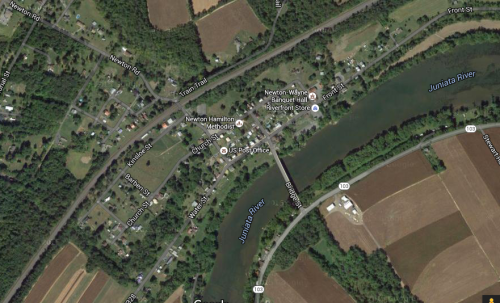 Aerial view of a small town near the Juniata River, surrounded by fields and roads.