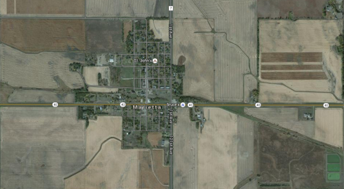 Aerial view of a small town with intersecting roads and surrounding agricultural fields.