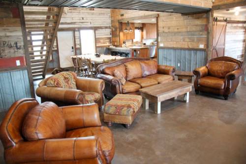 Cozy living room with leather furniture, a wooden coffee table, and rustic decor in a warm, inviting space.
