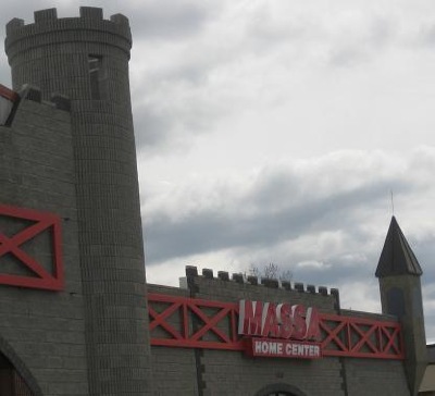 A castle-themed building with a sign reading "MASSA HOME CENTER" under a cloudy sky.