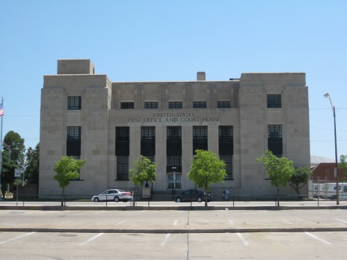 Historic U.S. Post Office and Court House building with a stone facade and trees in front.