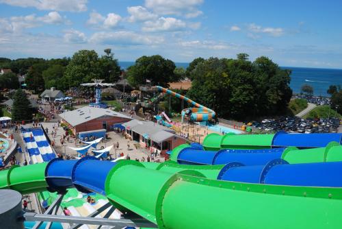 Aerial view of a water park featuring colorful slides, pools, and visitors enjoying the sunny day by the lake.