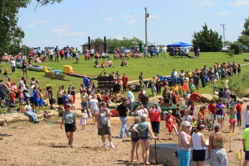 A crowded beach scene with people enjoying activities, sunbathing, and socializing on a sunny day.