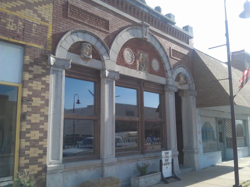 Historic brick building with arched windows and decorative stonework, featuring a sign for "The Street Building."