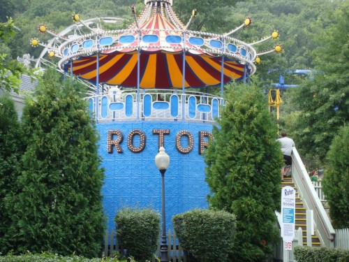A colorful amusement park ride called "Rotor," surrounded by greenery and a staircase leading up to it.