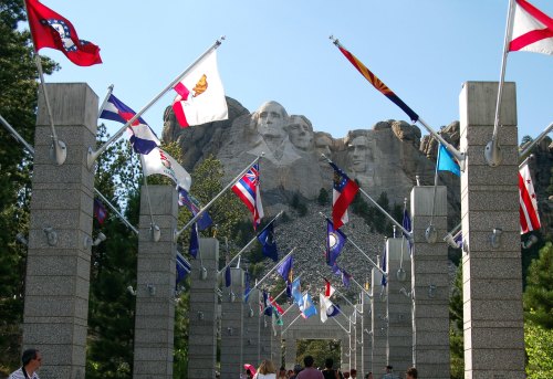 Visitors walk through a flag-lined pathway leading to the Mount Rushmore monument in South Dakota.