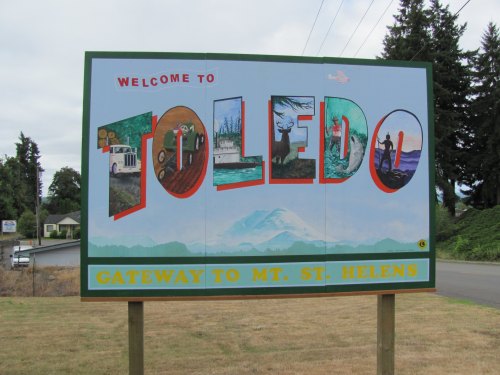 Welcome sign for Toledo, featuring colorful artwork and the text "Gateway to Mt. St. Helens."