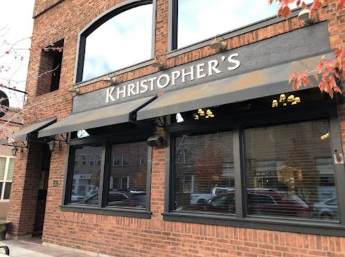 Exterior of Khristopher's restaurant, featuring a brick facade and large windows with awnings.