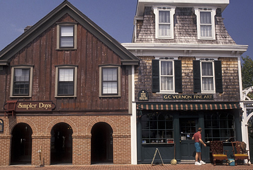 Two charming buildings: one with a wooden facade labeled "Simpler Days" and the other a fine art shop with a green entrance.