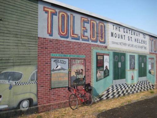 Mural in Toledo, featuring "Gateway to Mount St. Helens" with a bicycle parked in front.