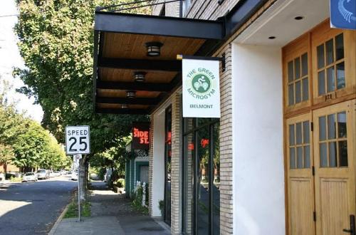 A street view of a building with a sign for "The Green Microgym" and a speed limit sign of 25 mph.