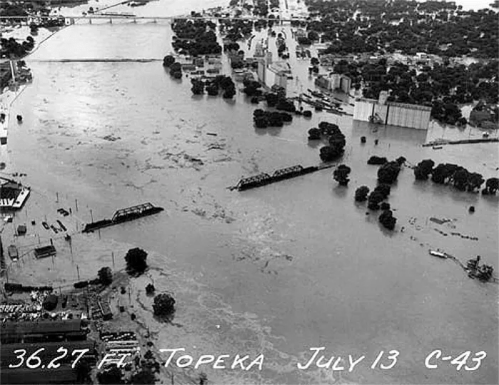 Aerial view of a flooded area in Topeka, July 13, showing submerged buildings and trees. Water level at 36.27 ft.
