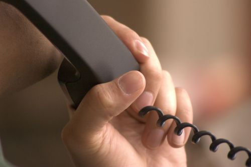 Person holding wired telephone