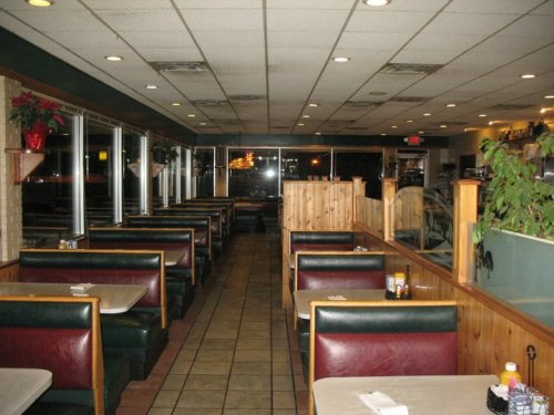Interior of a diner with empty booths, tiled floor, and large windows, creating a cozy atmosphere.