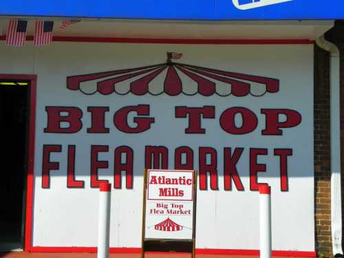 Sign for "Big Top Flea Market" with red and white striped awning and a smaller sign for Atlantic Mills.