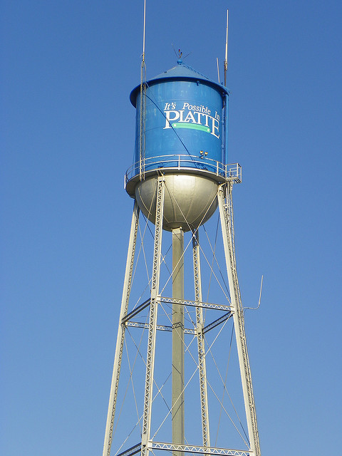 A blue water tower with the text "It's Possible in Platte" against a clear blue sky.
