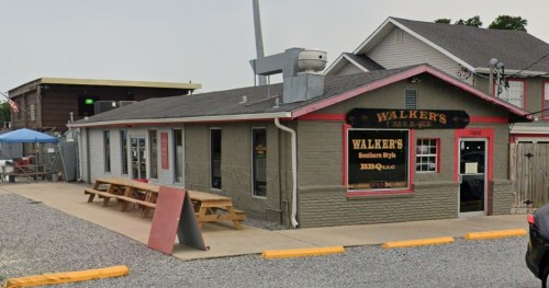 Exterior view of Walker's Southern Style Bar-B-Que, featuring a gray building with a red trim and outdoor seating.