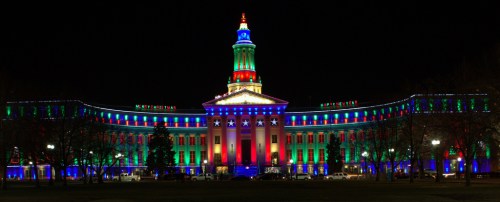 A brightly lit building at night, adorned with colorful red, green, and blue lights, creating a festive atmosphere.