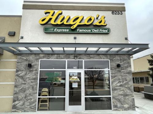 Exterior of Hugo's Express, featuring a sign and glass entrance with a modern design.