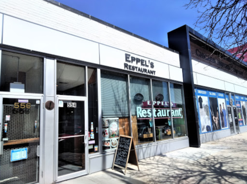 Exterior of Eppel's Restaurant with a sign, large windows, and a chalkboard menu outside on a sunny day.