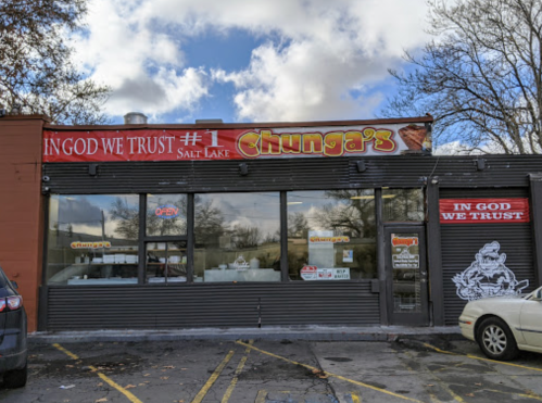 Exterior of Chunga's restaurant in Salt Lake, featuring a sign that reads "In God We Trust" and "Open."