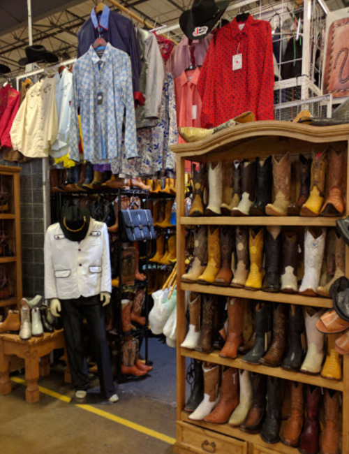 A vibrant display of cowboy boots and western clothing in a shop, showcasing various styles and colors.