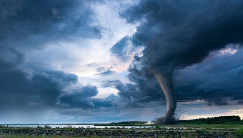 Powerful tornado sweeping across a rural landscape toward a ranch house beneath dark storm clouds.