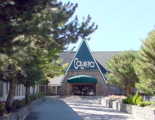 Entrance of Cal Neva Resort Hotel & Casino, featuring a triangular roof and surrounded by trees and landscaping.