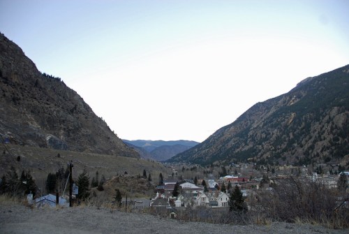 A scenic view of a valley surrounded by mountains, with a small town nestled below.