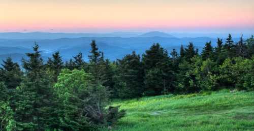 A serene landscape featuring rolling mountains and lush greenery under a pastel sunset sky.