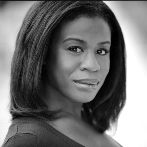 Black and white portrait of a woman with long hair, looking confidently at the camera with a soft expression.