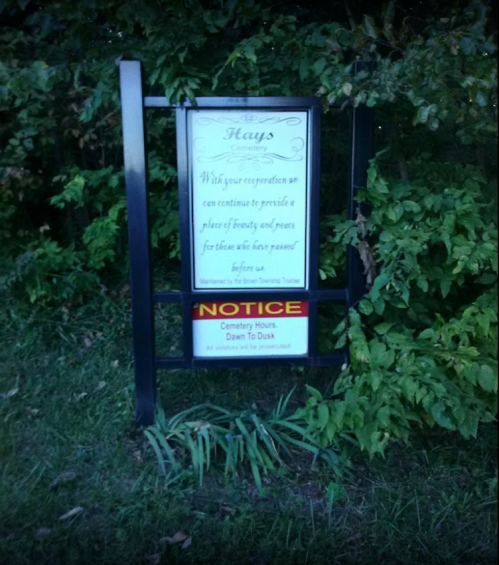 Sign at a cemetery outlining cooperation for maintaining beauty and peace, with hours from dawn to dusk.